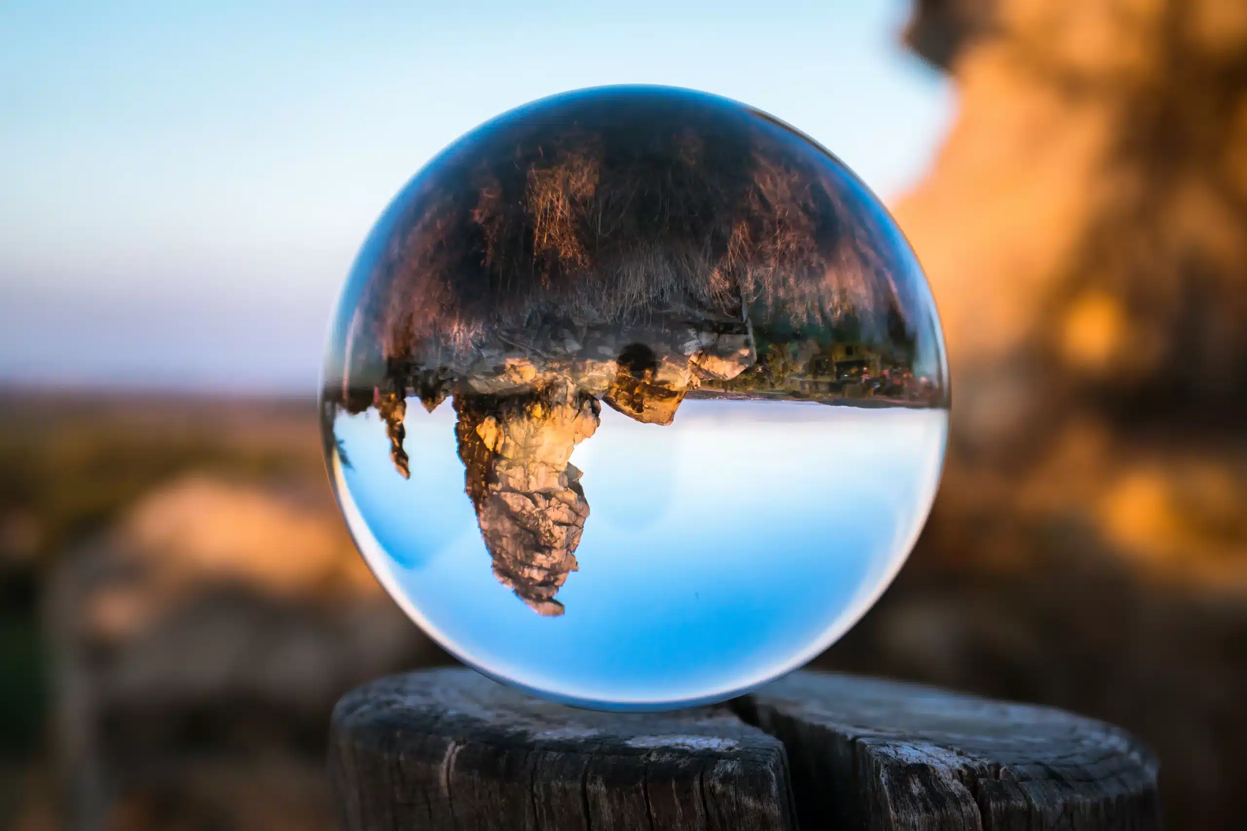 A glass sphere on a wooden post showing the landscape behind it upside down